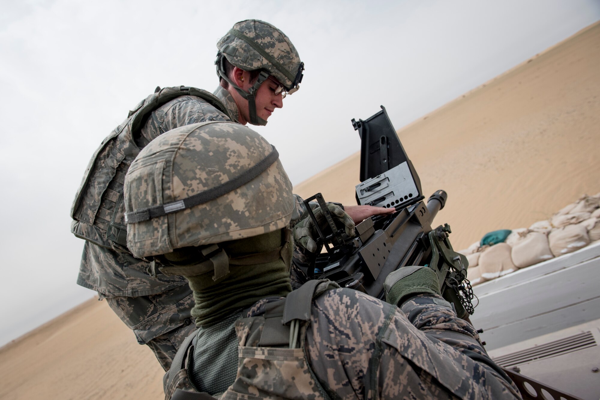 U.S. Air Force Senior Airman Ethan Grinder, 386th Expeditionary Security Forces Squadron, loads a Mark 19 40mm grenade machine gun for Staff Sgt. Jonathan Killebrew on May 7, 2014 at an undisclosed location in Southwest Asia. Both are deployed from the 99th Security Forces Squadron at Nellis Air Force Base, Nev. Qualified Security Forces members practice shooting every two months to maintain proficiency with the weapons system. (U.S. Air Force photo by Staff Sgt. Jeremy Bowcock)