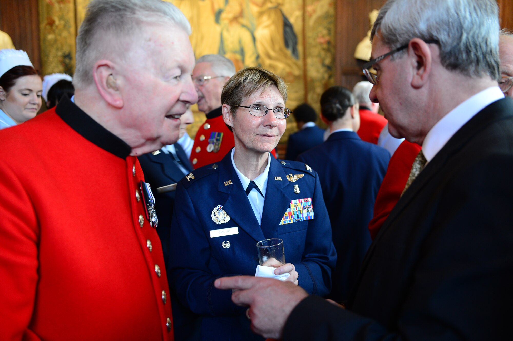 Col. Lynne Taylor, 48th Medical Group chief nurse, middle, speaks with Chelsea Pensioners, retired members of the British Army, before a remembrance ceremony at Westminster Abbey, England, May 7, 2014. The Florence Nightingale Foundation is a living memorial and hosts an annual remembrance service. (U.S. Air Force photo by Airman 1st Class Dawn M. Weber/Released)