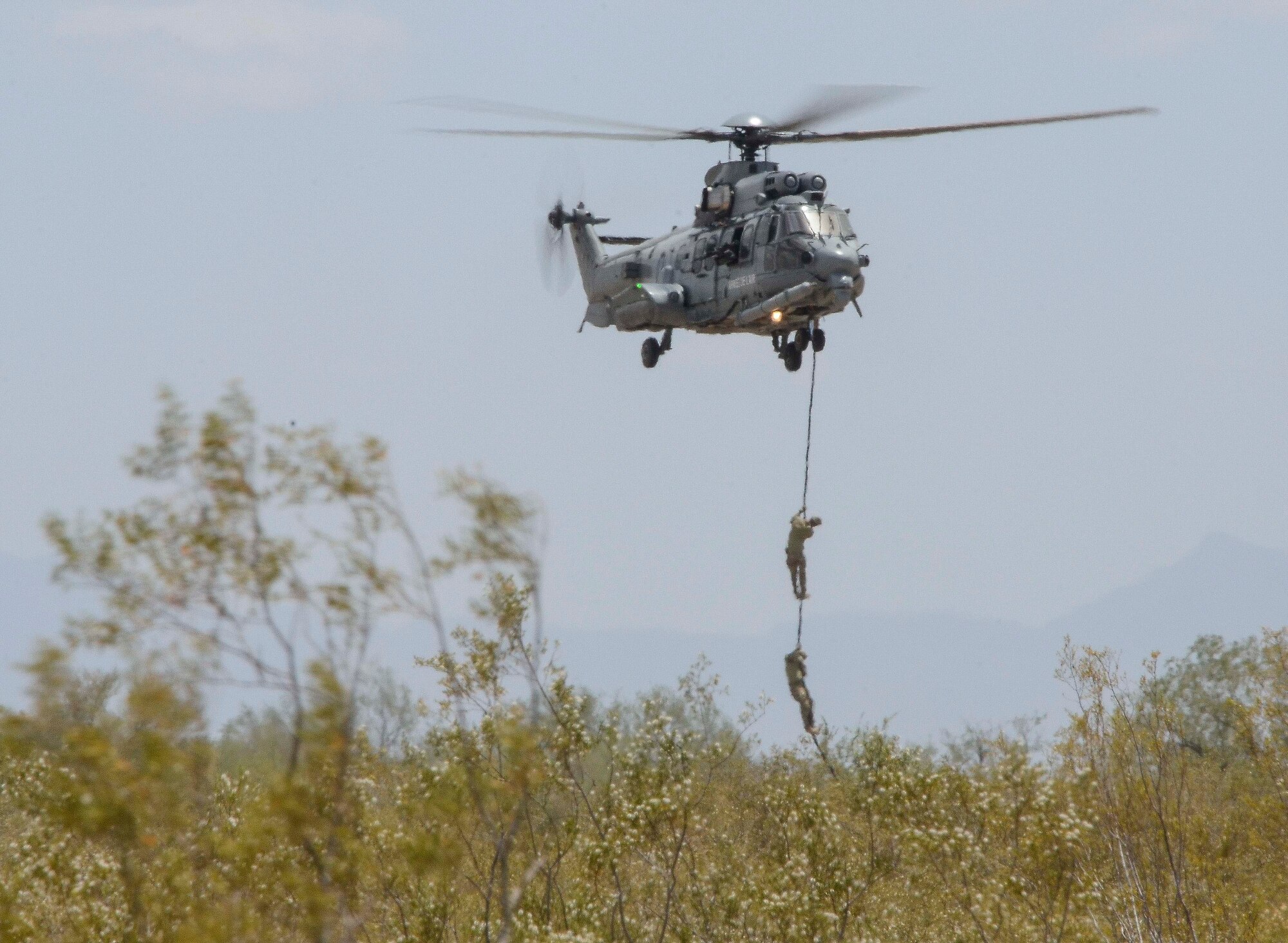 A French Eurocopter EC-735 Caracal hovers while personnel aboard fastrope down during Alternate Insertion Extraction  training during Exercise ANGEL THUNDER May 07, 2014 at Davis-Monthan Air Force Base, Ariz. ANGEL THUNDER 2014 is the largest and most realistic joint service, multinational, interagency combat search and rescue exercise designed to provide training for personnel recovery assets using a variety of scenarios to simulate deployment conditions and contingencies. Personnel recovery forces will train through the full spectrum of personnel recovery capabilities with ground recovery personnel, air assets, Special Forces teams and federal agents. (U.S. Air Force photo by Staff Sgt. Adam Grant/Released)