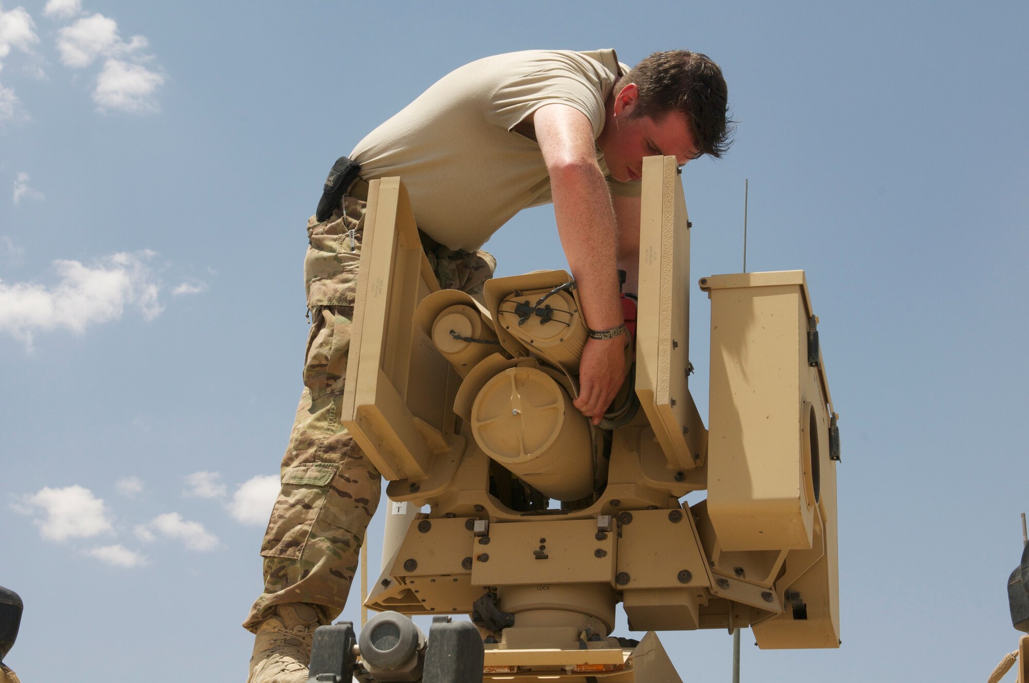 Senior Airman Matthew Edge secures the common remotely operated weapon station (CROW) on a mine-resistant assistant-vehicle (MRAP) after an open house May 3, 2014 held at the explosive ordnance shop at an undisclosed location in Southwest Asia. The open house was one of the events held to celebrate National Explosive Ordnance Disposal Day by members of EOD and to honor those EOD technicians who have lost their lives.  Edge, from Sumas, Washington, is an EOD technician who is deployed from the 627th Civil Engineer Squadron, Joint Base Lewis-McChord, Washington, in support of Operation Enduring Freedom. (U.S. Air Force photo/Senior Master Sgt. Allison Day)