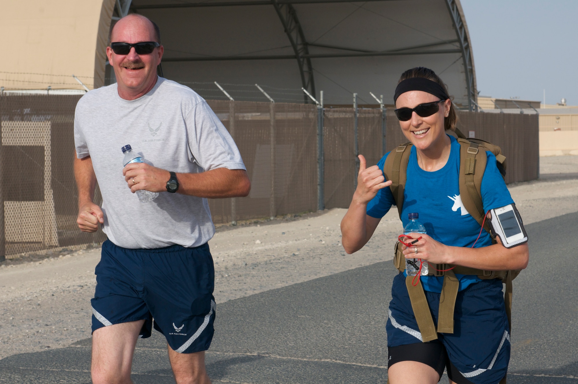 Two runners from 386th Air Expeditionary Wing display their Rock Spirit as they run May 3, 2014 during a 5K run held at an undisclosed location in Southwest Asia. The run was one of a series of events held to celebrate National Explosive Ordnance Disposal Day.  More than a 100 runners participated to honor EOD technicians who have paid the ultimate sacrifice. (U.S. Air Force photo/Senior Master Sgt. Allison Day)