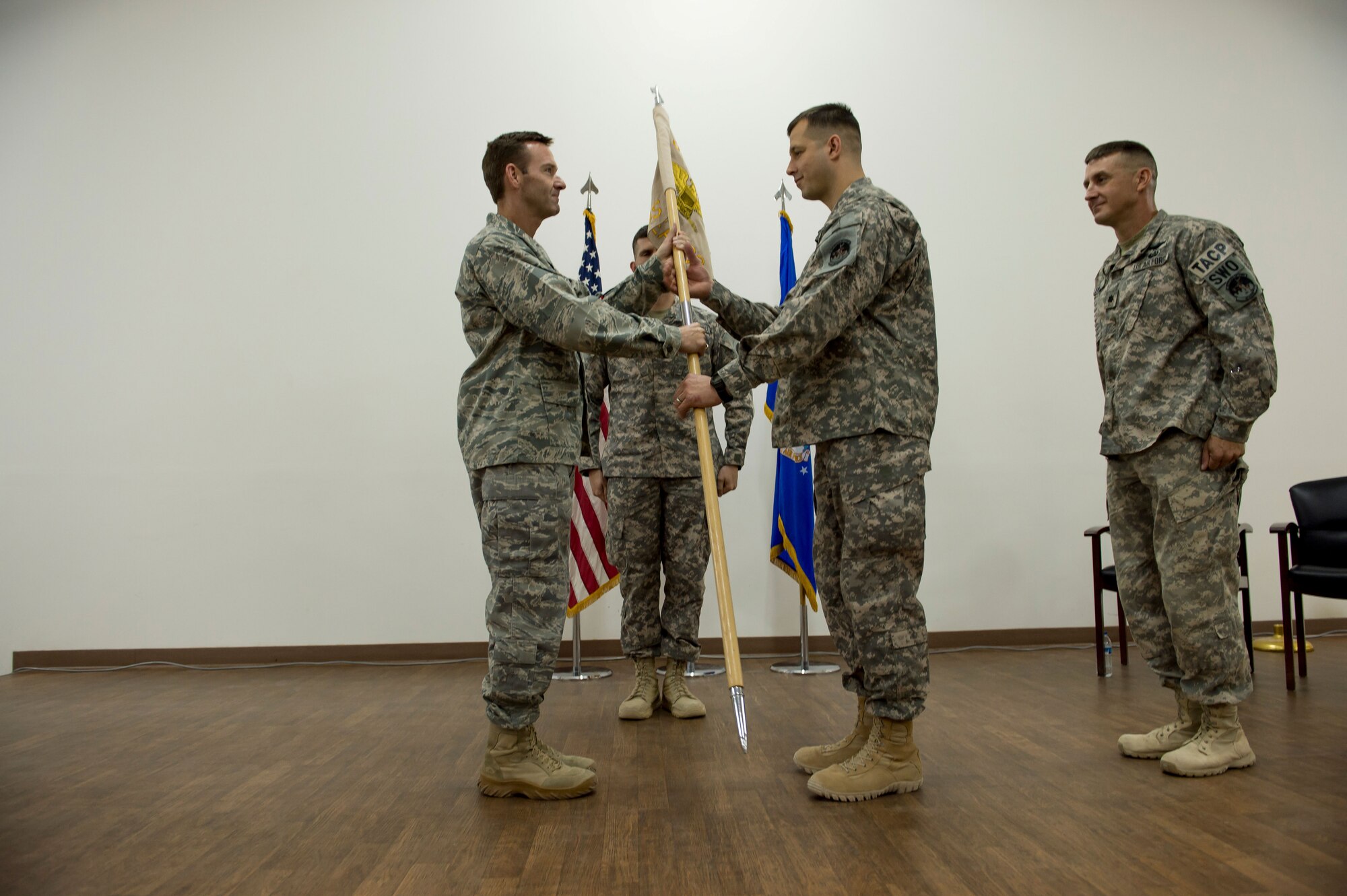 U.S. Air Force Col. Timothy Gosnell, 380th Expeditionary Operations Group commander, presents Lt. Col. Mark Johnson with the 82nd Expeditionary Air Support Operations Squadron guidon on May 3, 2014 at an undisclosed location is Southwest Asia. The passing of the guidon signifies Johnson’s official assumption of command. (U.S. Air Force photo by Staff Sgt. Jeremy Bowcock)