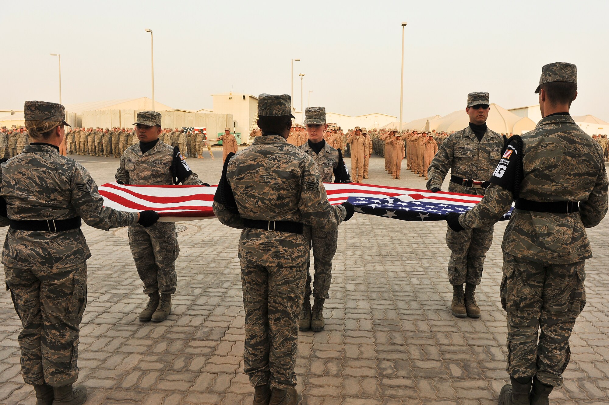 Airmen from the 380th Air Expeditionary Wing Base Honor Guard fold the U.S. flag during a Retreat Ceremony May 2, 2014, at an undisclosed location in Southwest Asia. Service members assigned to the wing gather once per month to participate in the ceremony. (U.S. Air Force photo byTech. Sgt. Russ Scalf/Released)