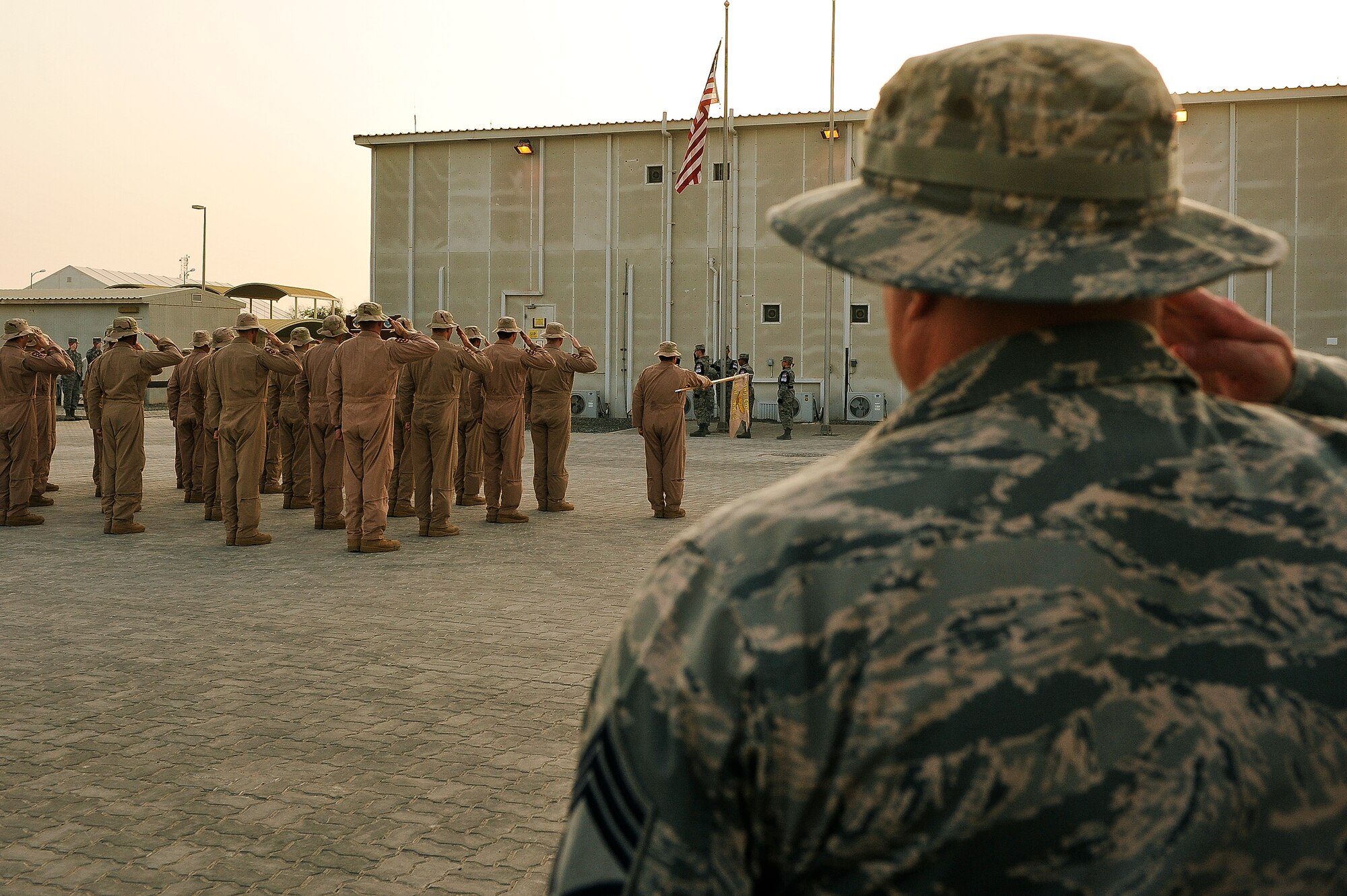 Airmen from the 380th Air Expeditionary Wing salute the U.S. flag during a retreat ceremony May 2, 2014, at an undisclosed location in Southwest Asia. Service members assigned to the wing gather once each month to participate in the ceremony.  (U.S. Air Force photo byTech. Sgt. Russ Scalf/Released)
