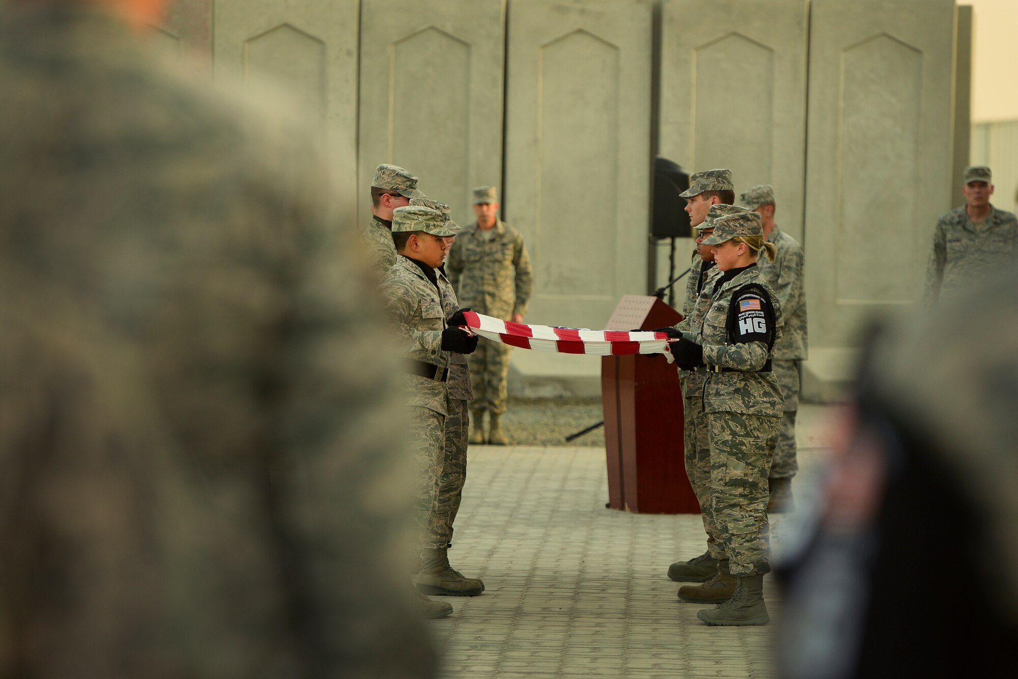 Airmen from the 380th Air Expeditionary Wing Base Honor Guard fold the U.S. flag during a Retreat Ceremony May 2, 2014, at an undisclosed location in Southwest Asia. Service members assigned to the wing gather once per month to participate in the ceremony.  (U.S. Air Force photo byTech. Sgt. Russ Scalf/Released)