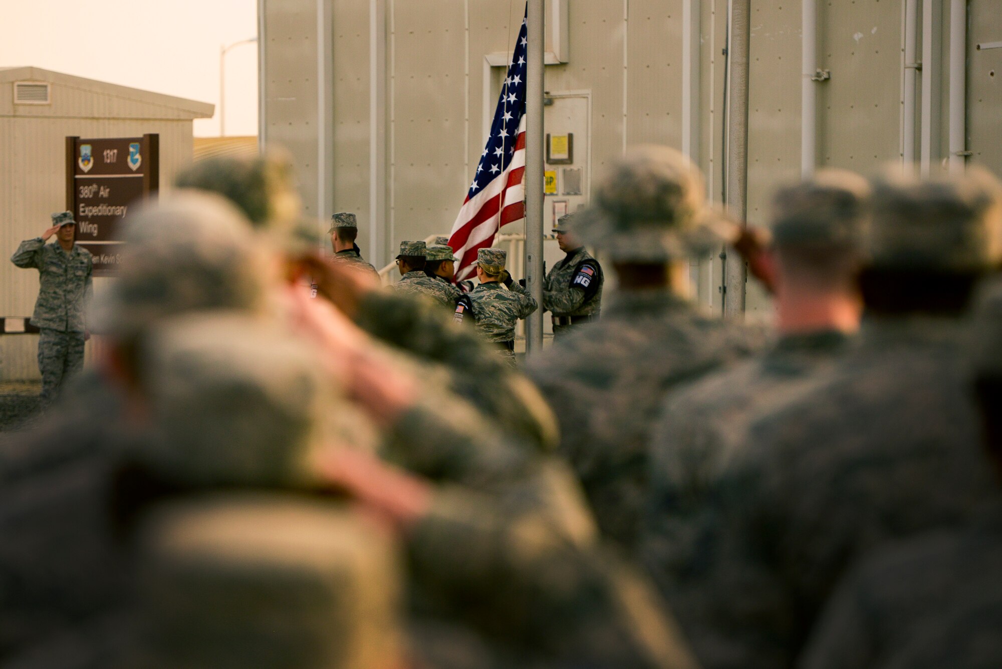 Airmen from the 380th Air Expeditionary Wing salute the U.S. flag during a Retreat Ceremony May 2, 2014, at an undisclosed location in Southwest Asia. Service members assigned to the wing gather once each month to participate in the ceremony.  (U.S. Air Force photo byTech. Sgt. Russ Scalf/Released)