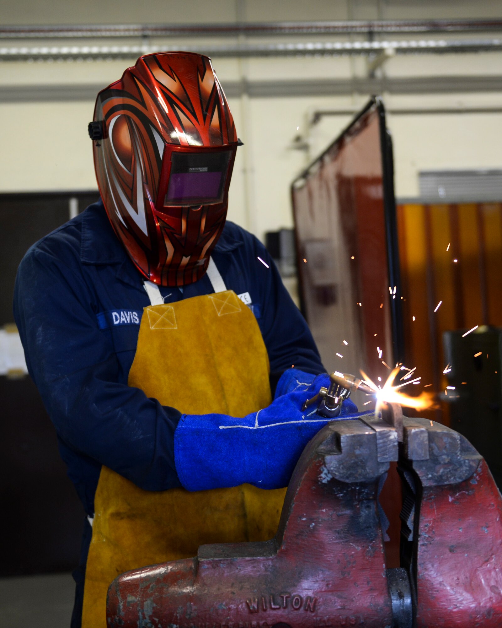 Airman 1st Class Robert Davis, 48th Logistics Readiness Squadron vehicle maintenance apprentice, welds a piece of metal for fabrication at the allied trades body shop on Royal Air Force Lakenheath, England, May 6, 2014. Body shop personnel make repairs and modifications to government vehicle exteriors. (U.S. Air Force photo by Airman 1st Class Nigel Sandridge/Released)