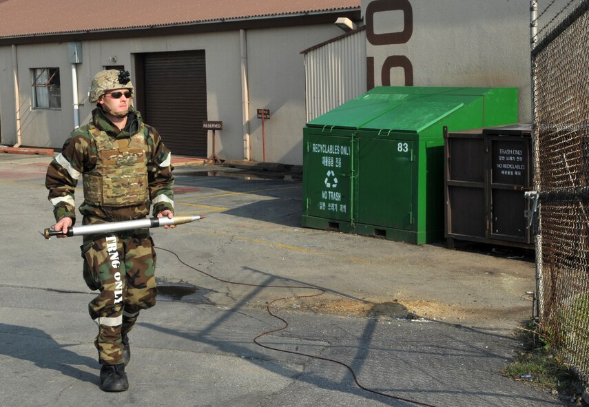 Staff Sgt. Andrew Trelly, 51st Civil Engineer Squadron explosive ordnance disposal team lead, retrieves a mock unexploded ordnance after successfully completing a training scenario during Operational Readiness Exercise Beverly Bulldog 14-02 at Osan Air Base, Republic of Korea, May 8, 2014. Trelly and his EOD team disarmed a UXO while participating in joint training with members of the ROK air force for the first time. (U.S. Air Force photo/Airman 1st Class Ashley J. Thum)