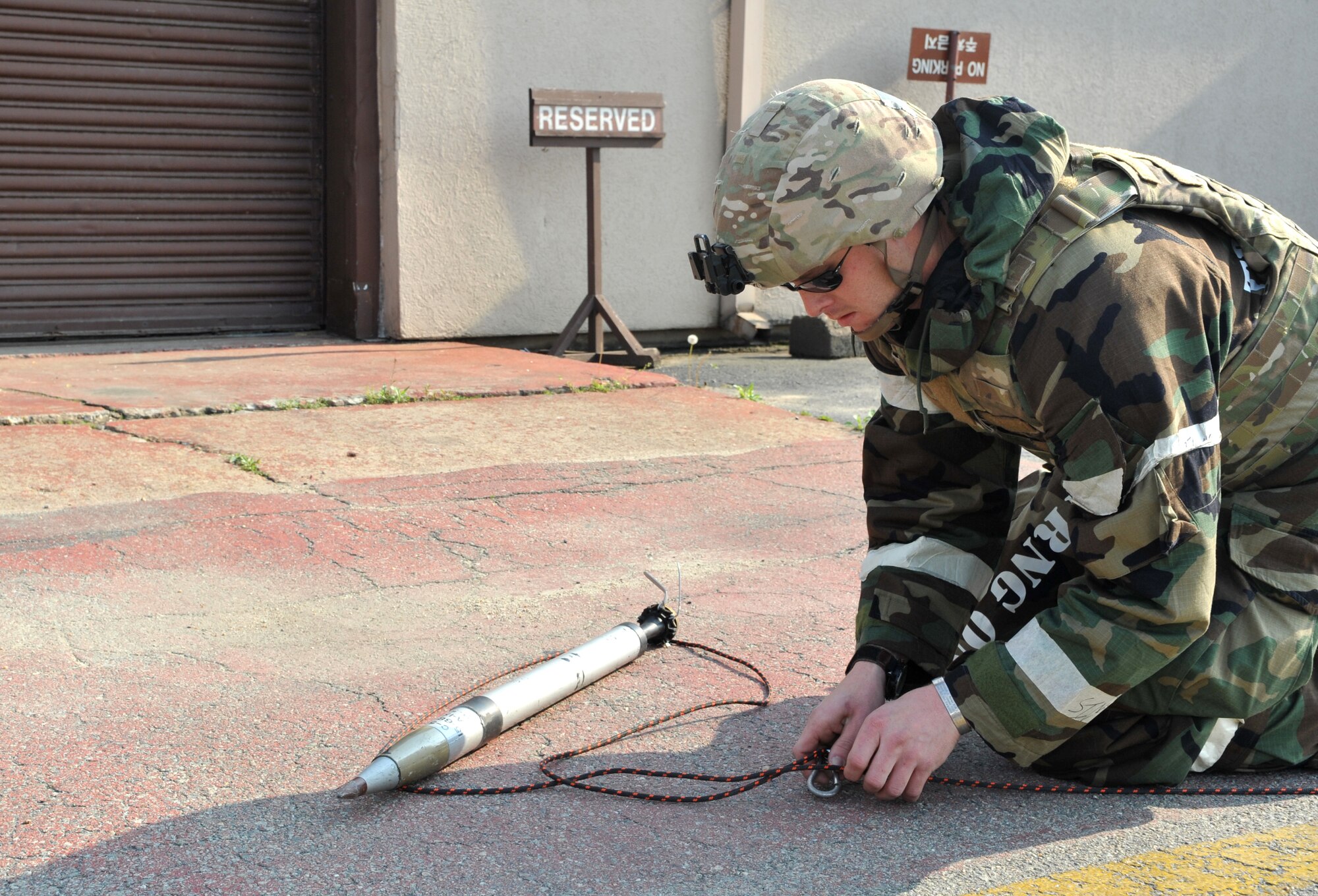 Staff Sgt. Andrew Trelly, 51st Civil Engineer Squadron explosive ordnance disposal team lead, places a tether around a mock unexploded ordnance during Operational Readiness Exercise Beverly Bulldog 14-02 at Osan Air Base, Republic of Korea, May 8, 2014. Osan participates in several OREs like BB 14-02 every year to help Airmen hone their wartime skills. (U.S. Air Force photo/Airman 1st Class Ashley J. Thum)