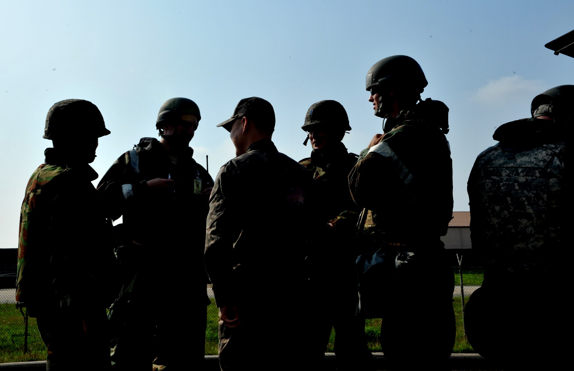 Explosive ordnance disposal technicians from the 51st Civil Engineer Squadron discuss an unexploded ordnance scenario with members of the Republic of Korea air force during Operational Readiness Exercise Beverly Bulldog 14-02 at Osan Air Base, ROK, May 8, 2014. The team was called to disarm a UXO near the 51st Logistics Readiness Squadron individual protective equipment building. (U.S. Air Force photo/Airman 1st Class Ashley J. Thum)