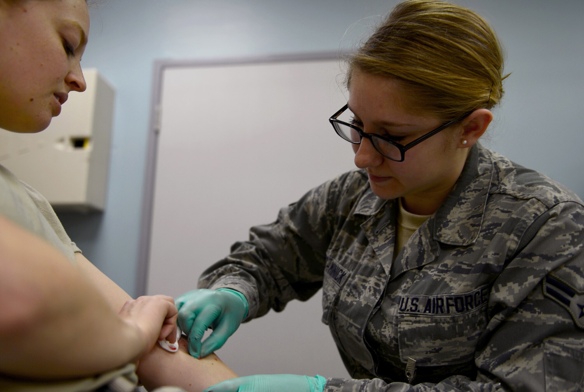 Airman 1st Class Destani Weiss-Minick, 48th Medical Operations Squadron emergency medical technician, draws blood from a patient at Royal Air Force Lakenheath, England, May 6, 2014. Weiss-Minick was nominated for a Liberty Spotlight by her unit leadership because she displays the Air Force core value of Excellence in All We Do. (U.S. Air Force photo by Airman 1st Class Dawn M. Weber/Released)