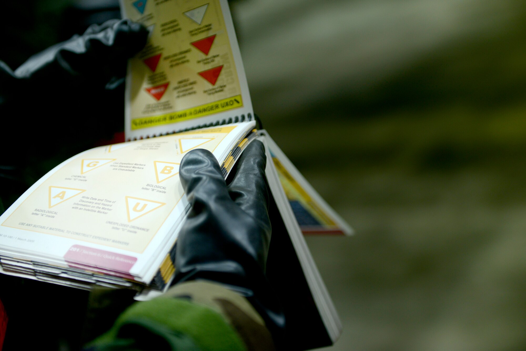 Senior Airman Todd Bennett, 51st Aircraft Maintenance Squadron, refers to his Airman's manual for proper contamination markers during Operational Readiness Exercise Beverly Bulldog 14-02 at Osan Air Base, Republic of Korea, May 9, 2014. The Airman's Manual is a valuable resource for Airmen during OREs, providing easy-to-locate information about living and working in a combat environment. (U.S. Air Force photo/Tech. Sgt. Micky M. Pena)