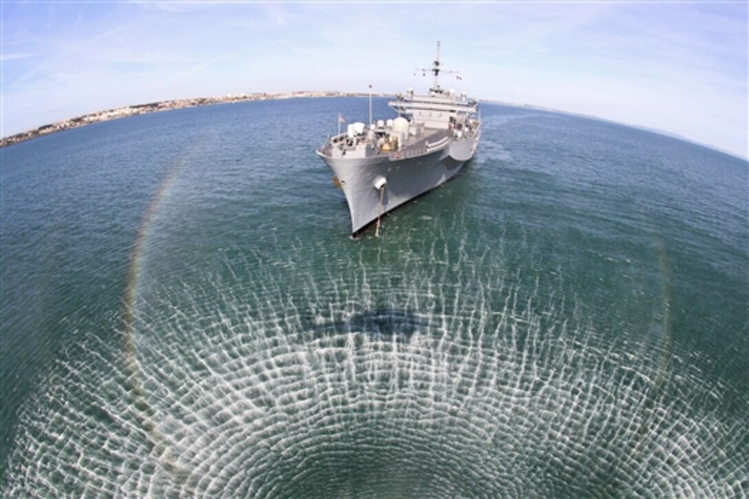 The amphibious command ship USS Mount Whitney sits at anchor off the coast of Lisbon, Portugal, May 4, 2014, as a helicopter hovers nearby during Trident Jaguar, a NATO-sponsored exercise. 
