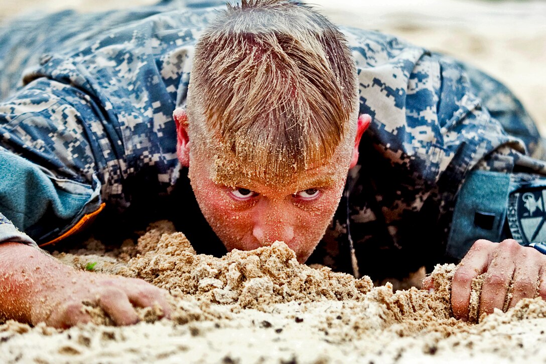 Army Cadet Erik Stoltzner low crawls under an obstacle during the air assault course at the Warrior Training Center at Camp Butler on Fort Benning, Ga., July 14, 2013. Stoltzner attends the University of Wisconsin.  
