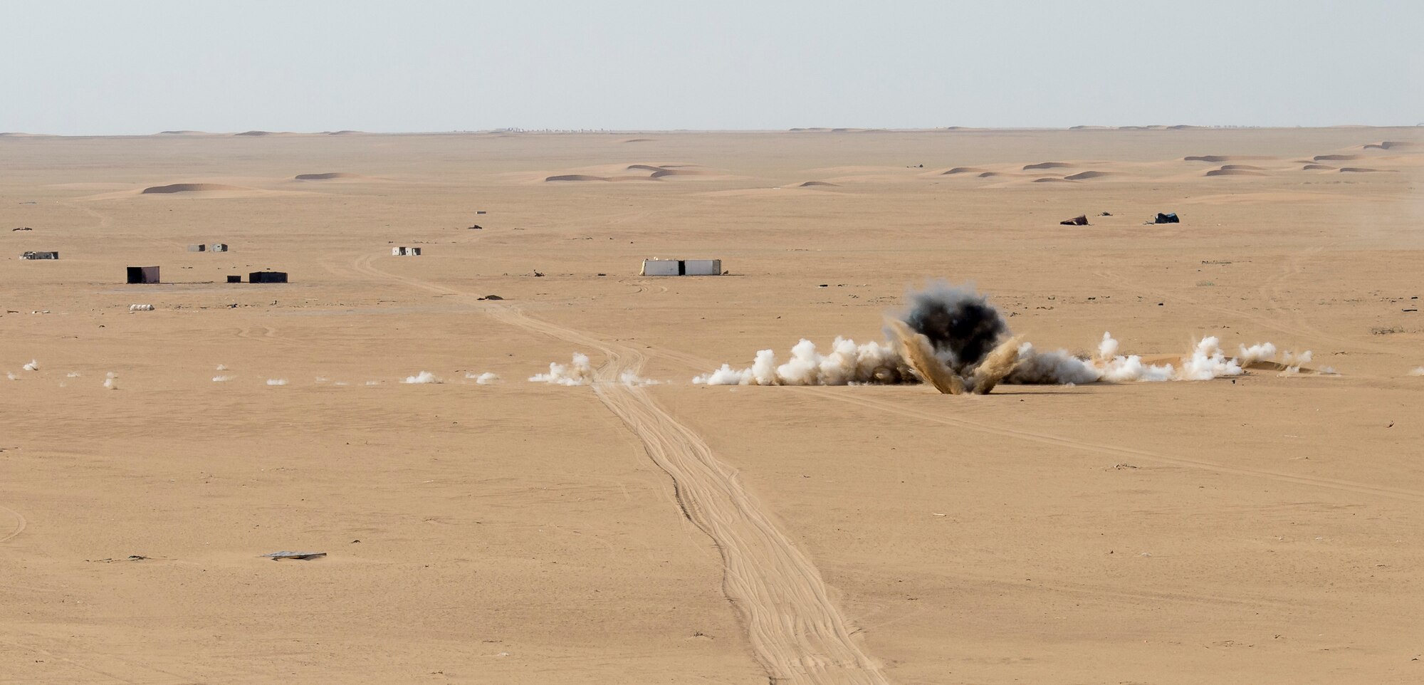 A 155mm howitzer round explodes as it hits its target during a Joint Operations live fire exercise on May 7, 2014 at an undisclosed location in Southwest Asia. The operation consisted of Army, Air Force, and Navy personnel working together to conduct a coordinated strike against a single target. (U.S. Air Force photo by Staff Sgt. Jeremy Bowcock)