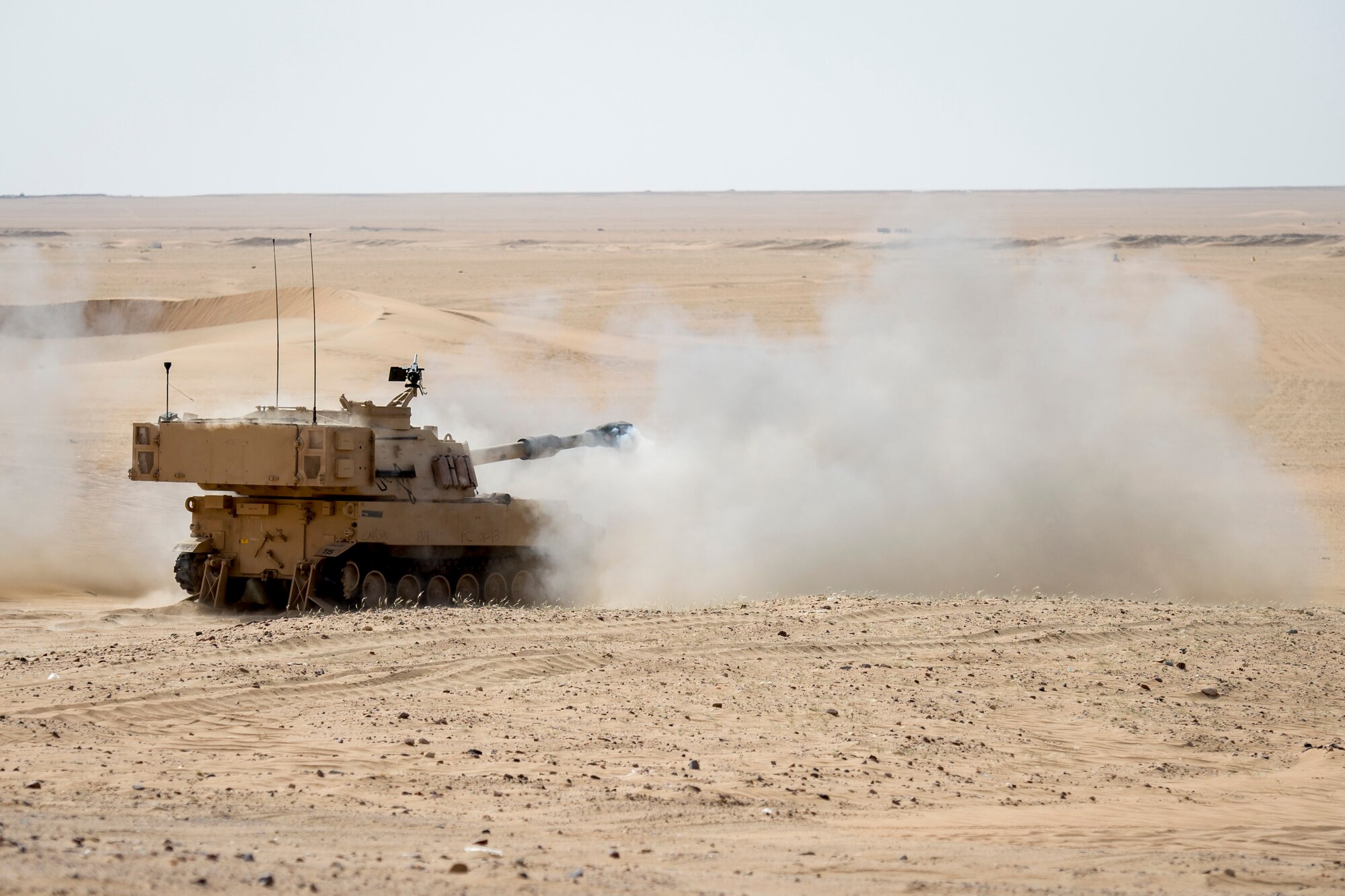 A U.S. Army M109A6 Paladin fires a 155mm artillery round during a Joint Operations live fire exercise on May 7, 2014 at an undisclosed location in Southwest Asia. The operation consisted of Army, Air Force, and Navy personnel working together to conduct a coordinated strike against a single target. (U.S. Air Force photo by Staff Sgt. Jeremy Bowcock)