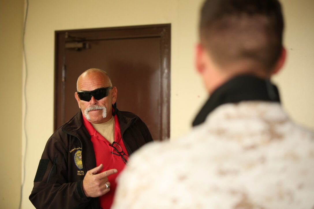 Mike McSwain, an instructor at Marine Corps Police Academy East, critiques Marines with the Provost Marshal’s Office after they completed a scenario during the Advanced Active Shooter course aboard Marine Corps Air Station Iwakuni, Japan, April 7 - 18, 2014. Instructors with the police academy travel to multiple Marine Corps bases to train military policemen.
