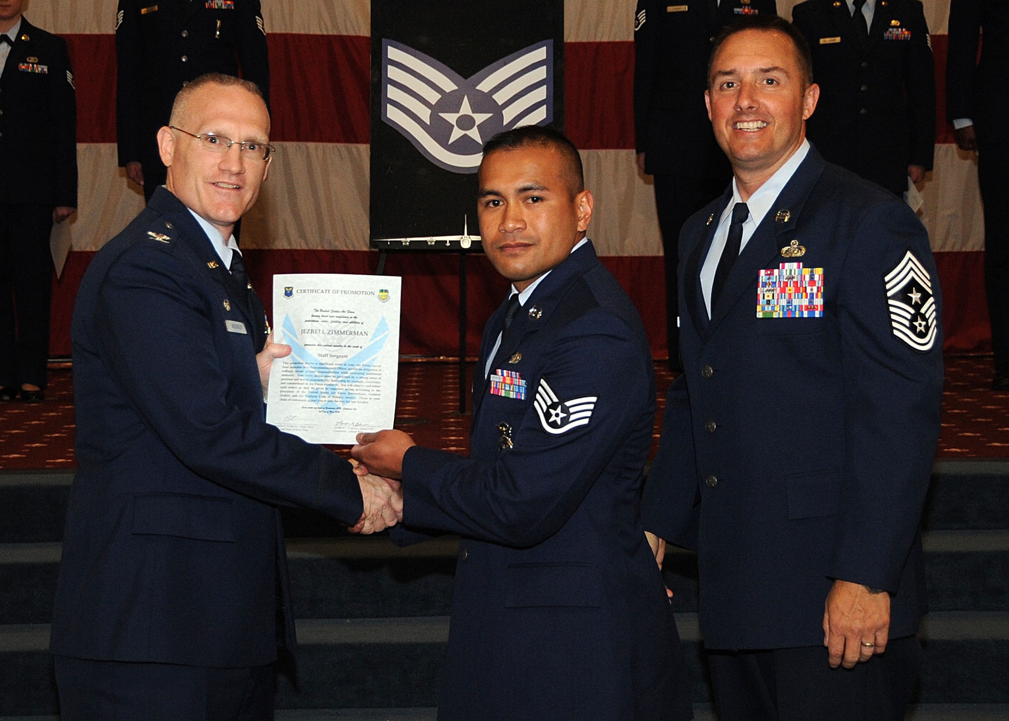 Staff Sgt. Jezrell Zimmerman, 2nd Security Forces Squadron, receives a certificate of promotion from Col. Michael Adderley, 2nd Operations Group commander, and Chief Master Sgt. Curtis Storms, 2nd Bomb Wing command chief, during the Wing Promotion Ceremony on Barksdale Air Force Base, La., April 30, 2014. (U.S. Air Force photo/Senior Airman Kristin High)