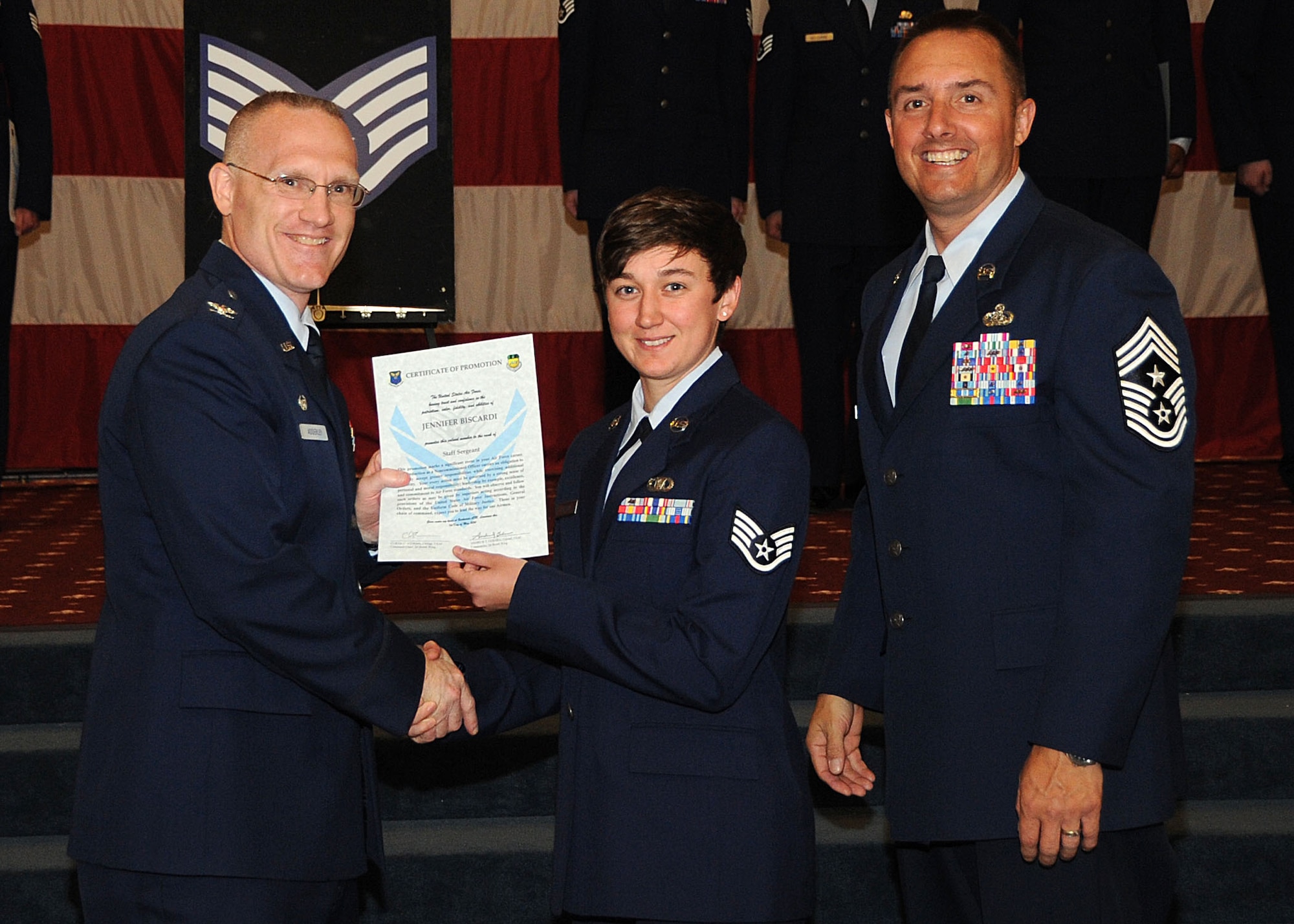 Staff Sgt. Jennifer Biscardi, 2nd Operations Support Squadron, receives a certificate of promotion from Col. Michael Adderley, 2nd Operations Group commander, and Chief Master Sgt. Curtis Storms, 2nd Bomb Wing command chief, during the Wing Promotion Ceremony on Barksdale Air Force Base, La., April 30, 2014. (U.S. Air Force photo/Senior Airman Kristin High)