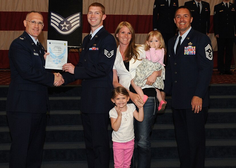 Staff Sgt. Joshua Fisher, 2nd Maintanence Squadron, receives a certificate of promotion from Col. Michael Adderley, 2nd Operations Group commander, and Chief Master Sgt. Curtis Storms, 2nd Bomb Wing command chief, during the Wing Promotion Ceremony on Barksdale Air Force Base, La., April 30, 2014. (U.S. Air Force photo/Senior Airman Kristin High)