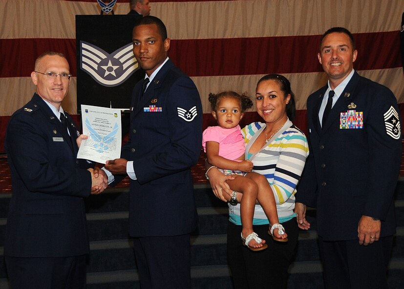 Staff Sgt. Jeffery Hairston, 2nd Contracting Squadron, receives a certificate of promotion from Col. Michael Adderley, 2nd Operations Group commander, and Chief Master Sgt. Curtis Storms, 2nd Bomb Wing command chief, during the Wing Promotion Ceremony on Barksdale Air Force Base, La., April 30, 2014. (U.S. Air Force photo/Senior Airman Kristin High)