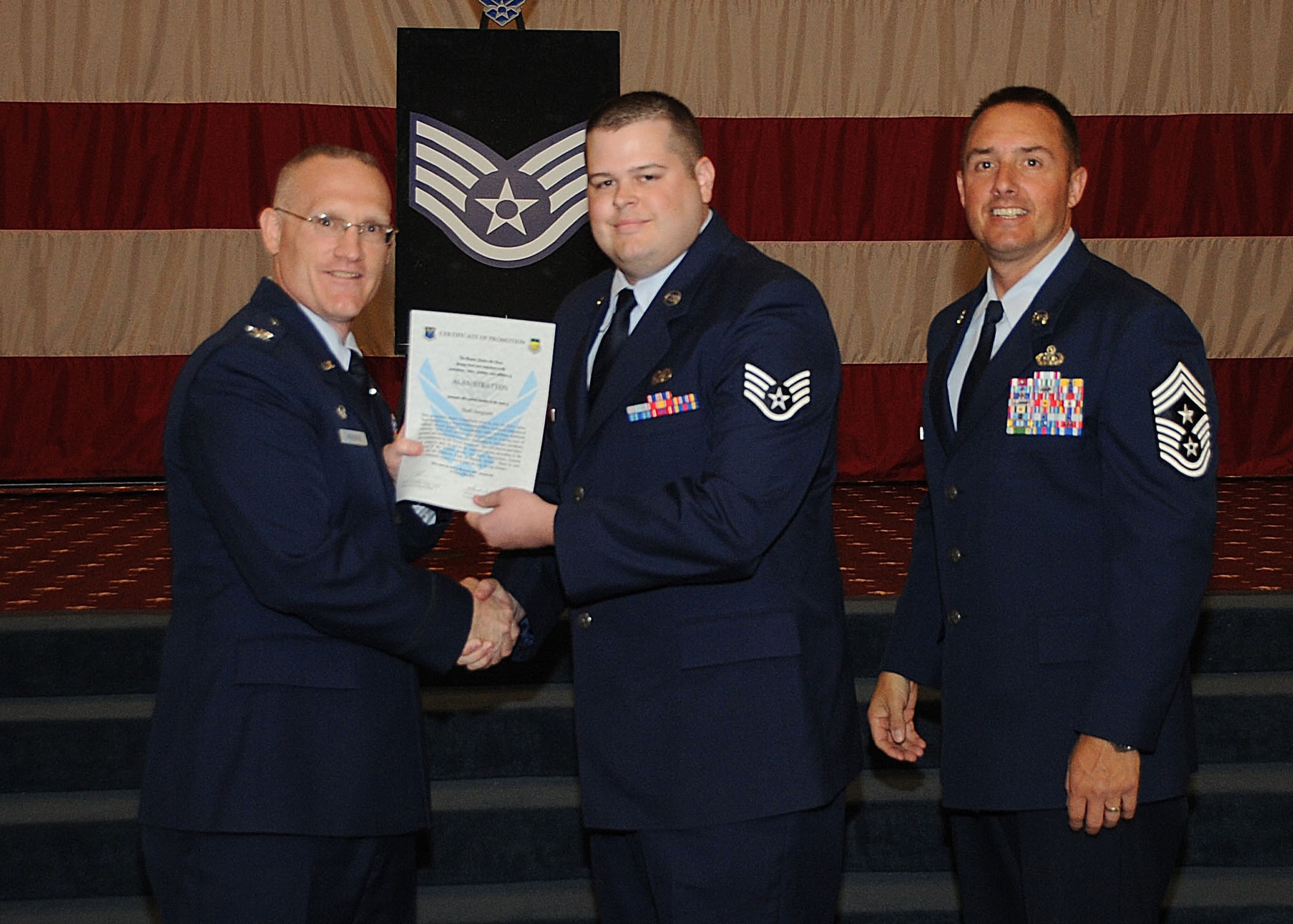 Staff Sgt. Alan Stratton, 2nd Communications Squadron, receives a certificate of promotion from Col. Michael Adderley, 2nd Operations Group commander, and Chief Master Sgt. Curtis Storms, 2nd Bomb Wing command chief, during the Wing Promotion Ceremony on Barksdale Air Force Base, La., April 30, 2014. (U.S. Air Force photo/Senior Airman Kristin High)