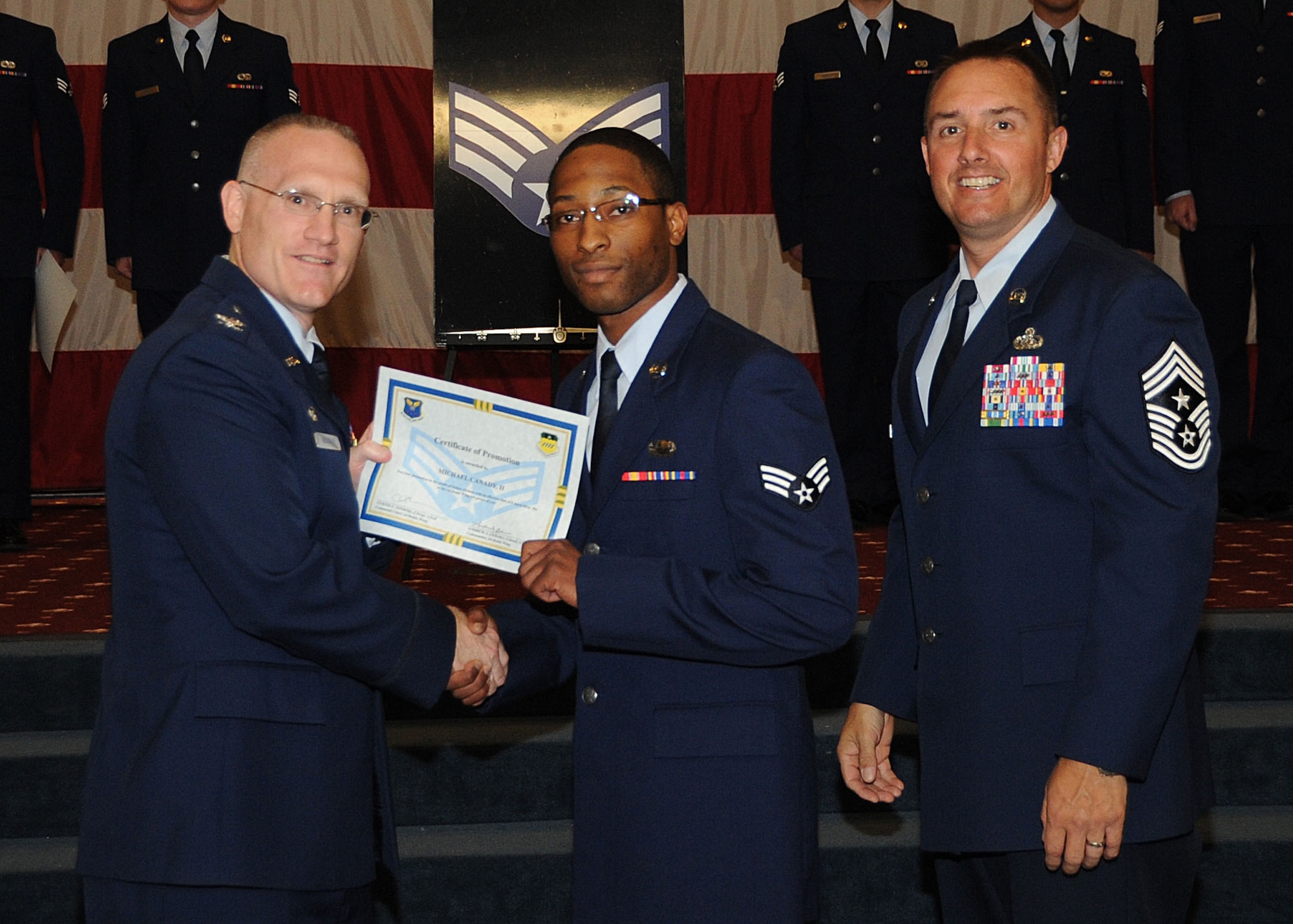 Senior Airman Michael Canady II, 2nd Operations Support Squadron, receives a certificate of promotion from Col. Michael Adderley, 2nd Operations Group commander, and Chief Master Sgt. Curtis Storms, 2nd Bomb Wing command chief, during the Wing Promotion Ceremony on Barksdale Air Force Base, La., April 30, 2014. (U.S. Air Force photo/Senior Airman Kristin High)