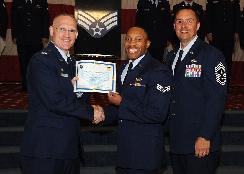 Senior Airman John Porter III, 2nd Operations Support Squadron, receives a certificate of promotion from Col. Michael Adderley, 2nd Operations Group commander, and Chief Master Sgt. Curtis Storms, 2nd Bomb Wing command chief, during the Wing Promotion Ceremony on Barksdale Air Force Base, La., April 30, 2014. (U.S. Air Force photo/Senior Airman Kristin High)