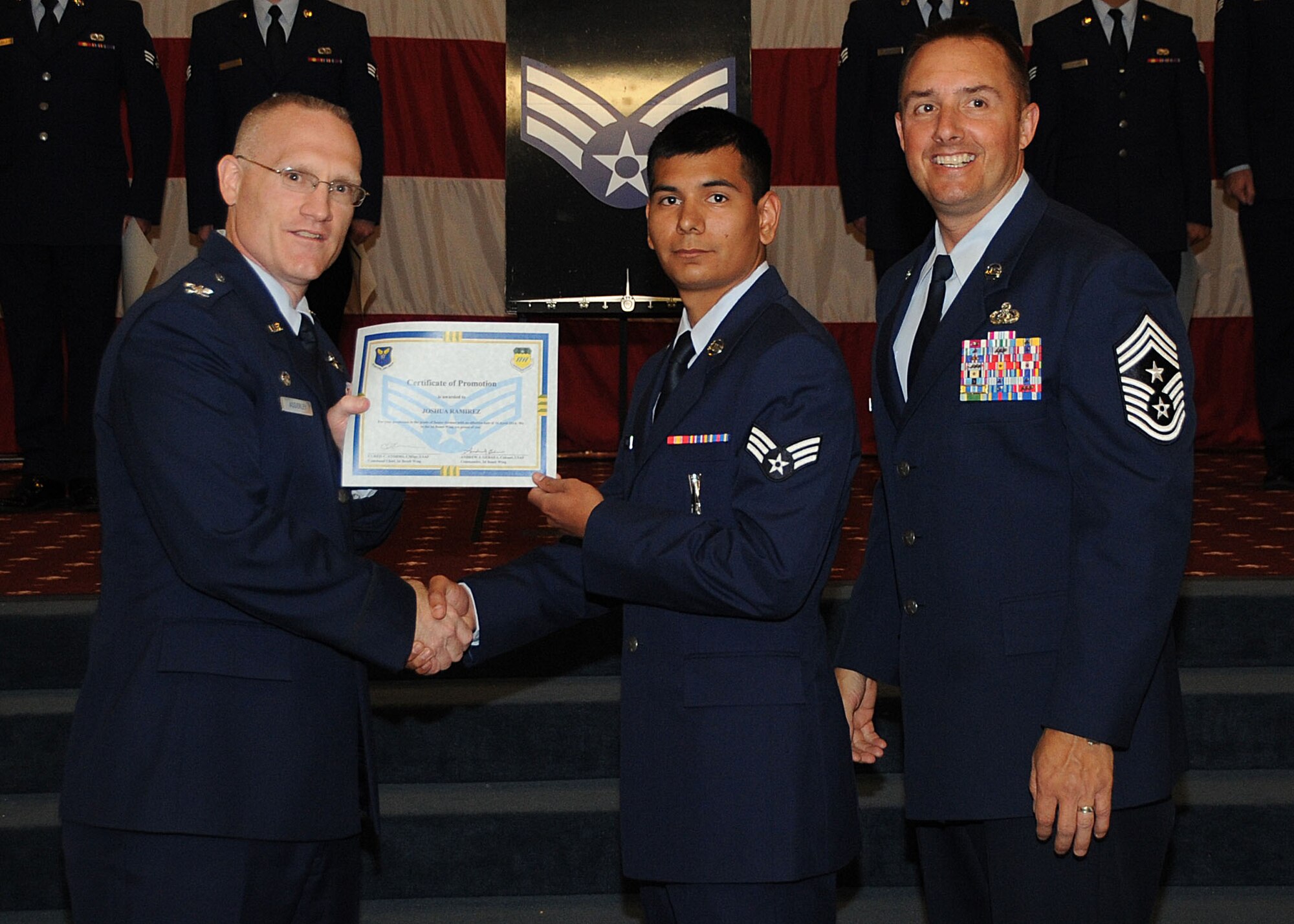 Senior Airman Joshua Ramirez, 2nd Munitions Squadron, receives a certificate of promotion from Col. Michael Adderley, 2nd Operations Group commander, and Chief Master Sgt. Curtis Storms, 2nd Bomb Wing command chief, during the Wing Promotion Ceremony on Barksdale Air Force Base, La., April 30, 2014. (U.S. Air Force photo/Senior Airman Kristin High)