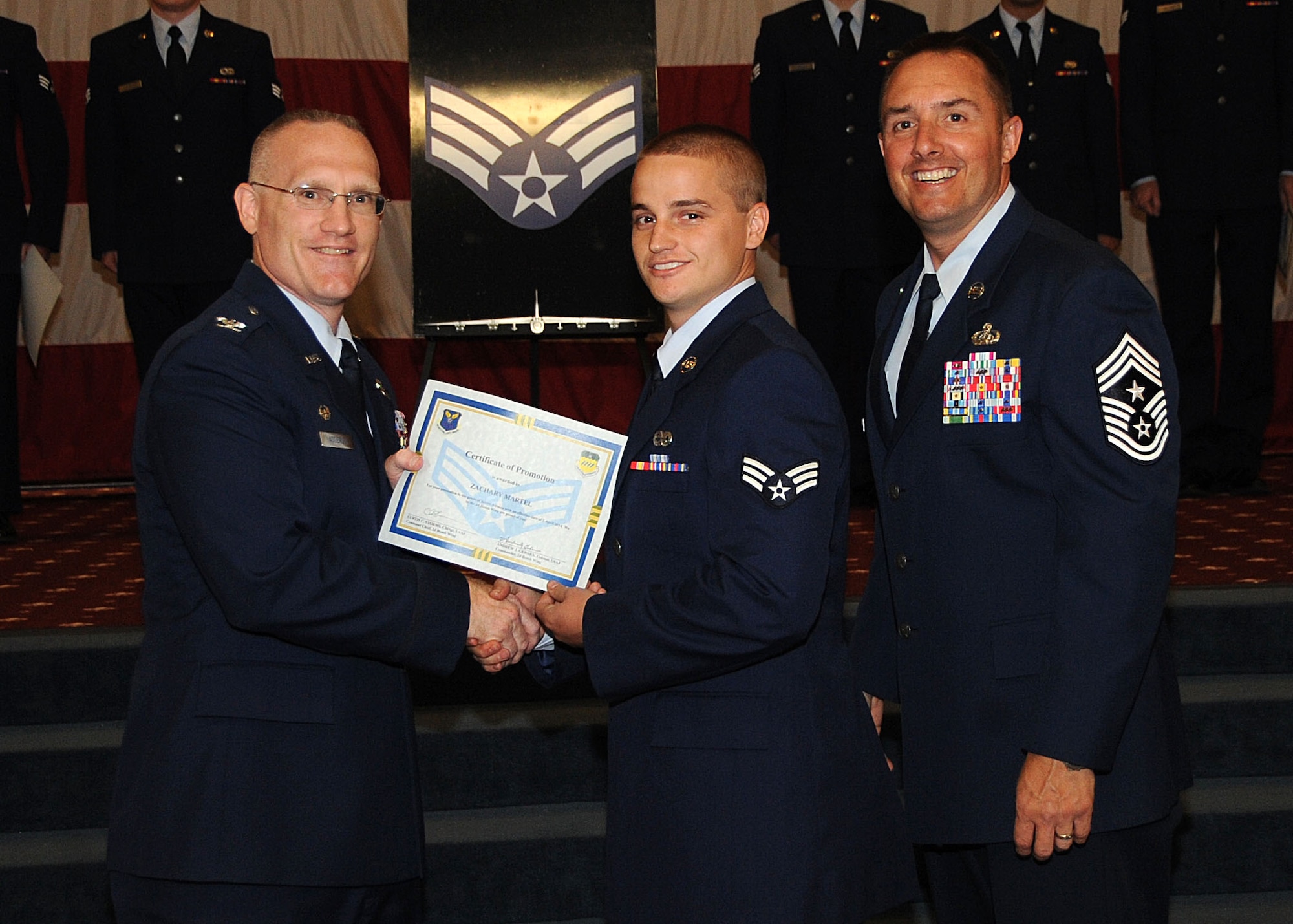 Senior Airman Zachary Martel, 2nd Munitions Squadron, receives a certificate of promotion from Col. Michael Adderley, 2nd Operations Group commander, and Chief Master Sgt. Curtis Storms, 2nd Bomb Wing command chief, during the Wing Promotion Ceremony on Barksdale Air Force Base, La., April 30, 2014. (U.S. Air Force photo/Senior Airman Kristin High)