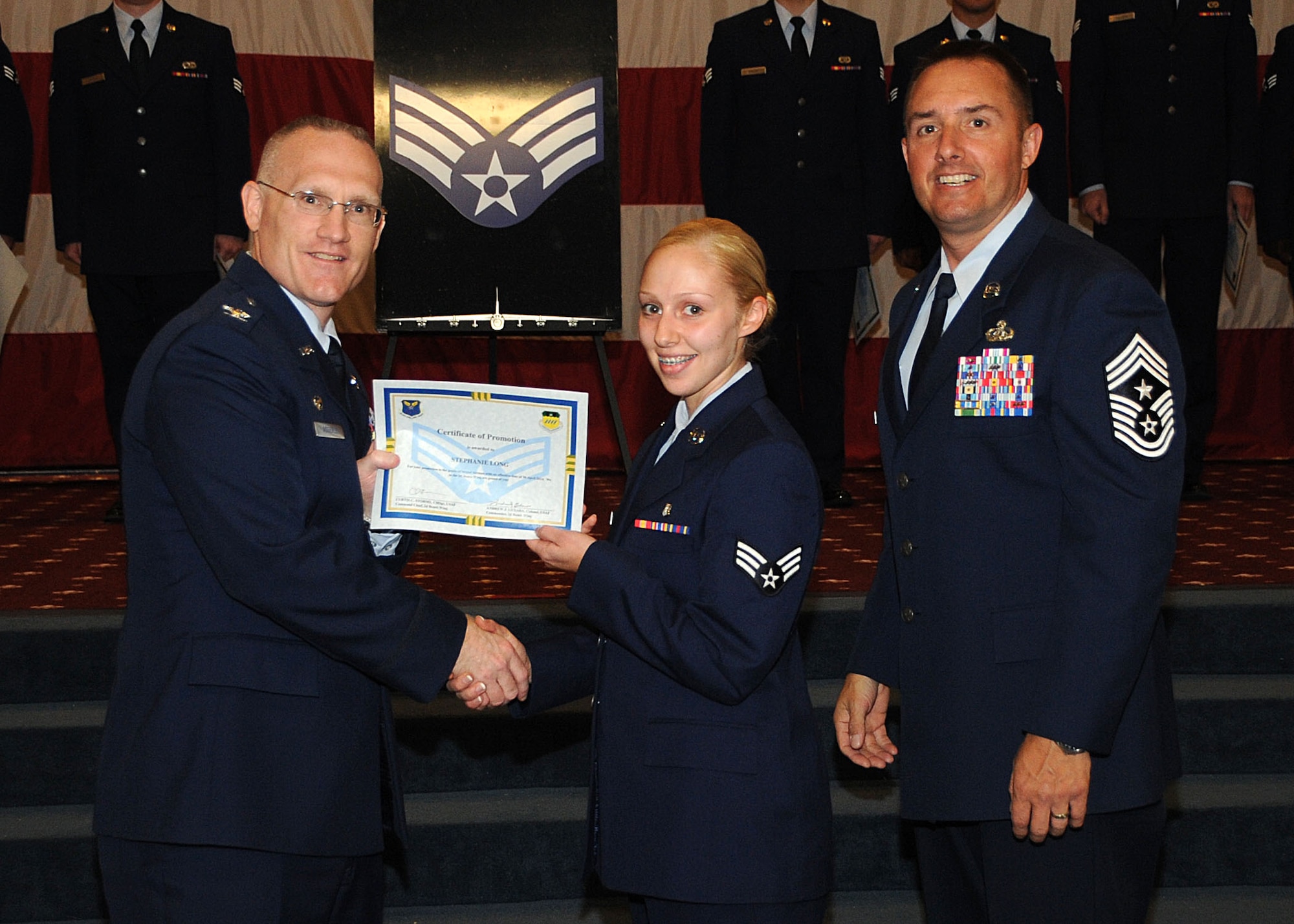 Senior Airman Stephanie Long, 2nd Medical Support Squadron, receives a certificate of promotion from Col. Michael Adderley, 2nd Operations Group commander, and Chief Master Sgt. Curtis Storms, 2nd Bomb Wing command chief, during the Wing Promotion Ceremony on Barksdale Air Force Base, La., April 30, 2014. (U.S. Air Force photo/Senior Airman Kristin High)