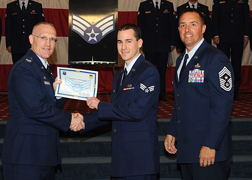 Senior Airman Zachary Voelker, 2nd Maintenance Squadron, receives a certificate of promotion from Col. Michael Adderley, 2nd Operations Group commander, and Chief Master Sgt. Curtis Storms, 2nd Bomb Wing command chief, during the Wing Promotion Ceremony on Barksdale Air Force Base, La., April 30, 2014. (U.S. Air Force photo/Senior Airman Kristin High)