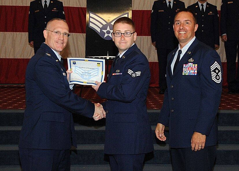 Senior Airman Trevor Parker, 2nd Maintenance Squadron, receives a certificate of promotion from Col. Michael Adderley, 2nd Operations Group commander, and Chief Master Sgt. Curtis Storms, 2nd Bomb Wing command chief, during the Wing Promotion Ceremony on Barksdale Air Force Base, La., April 30, 2014. (U.S. Air Force photo/Senior Airman Kristin High)