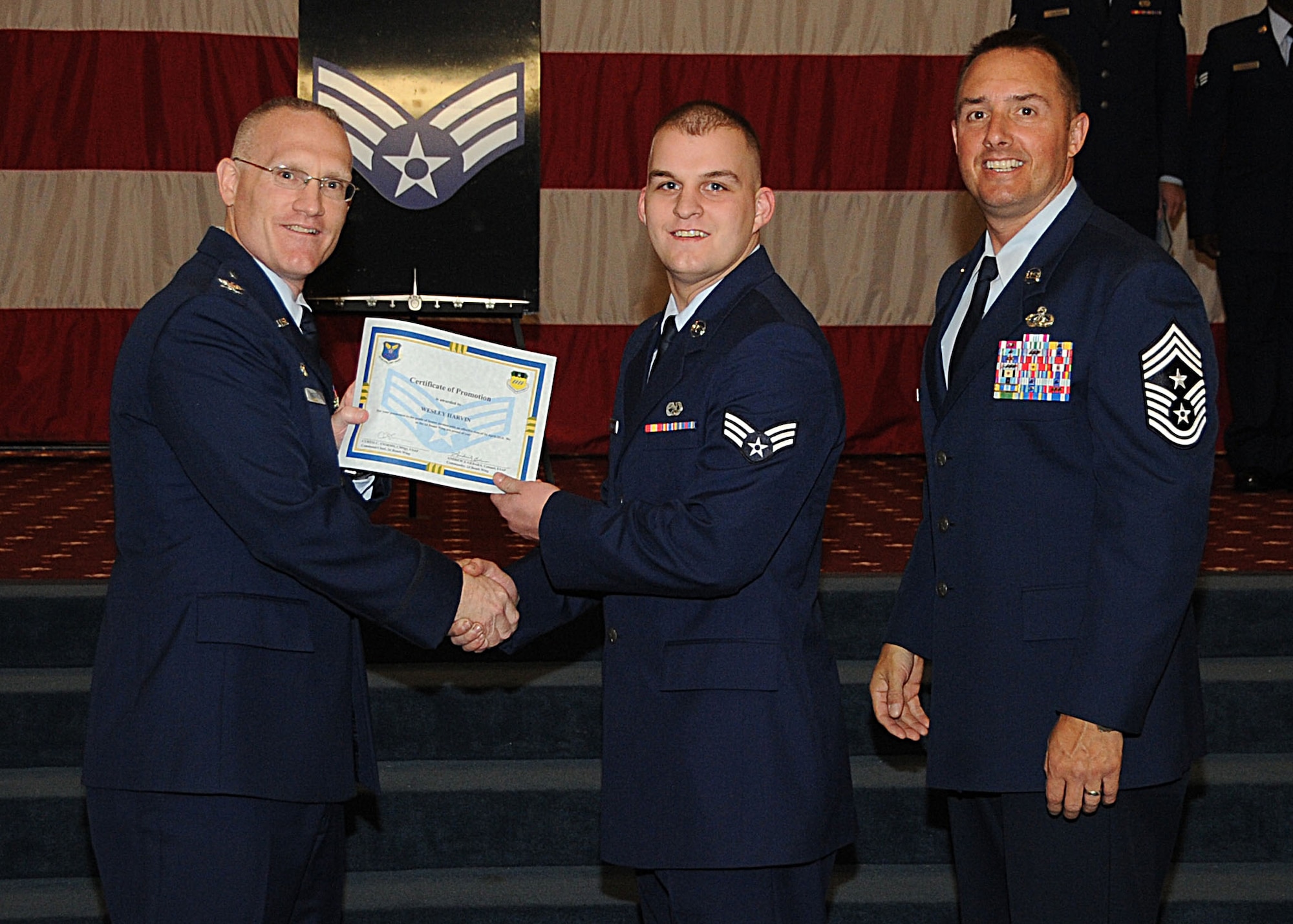 Senior Airman Wesley Harvin, 2nd Maintenance Squadron, receives a certificate of promotion from Col. Michael Adderley, 2nd Operations Group commander, and Chief Master Sgt. Curtis Storms, 2nd Bomb Wing command chief, during the Wing Promotion Ceremony on Barksdale Air Force Base, La., April 30, 2014. (U.S. Air Force photo/Senior Airman Kristin High)