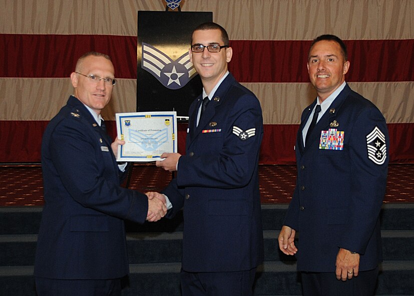 Senior Airman Anthony Wilson, 2nd Aircraft Maintenance Squadron, receives a certificate of promotion from Col. Michael Adderley, 2nd Operations Group commander, and Chief Master Sgt. Curtis Storms, 2nd Bomb Wing command chief, during the Wing Promotion Ceremony on Barksdale Air Force Base, La., April 30, 2014. (U.S. Air Force photo/Senior Airman Kristin High)