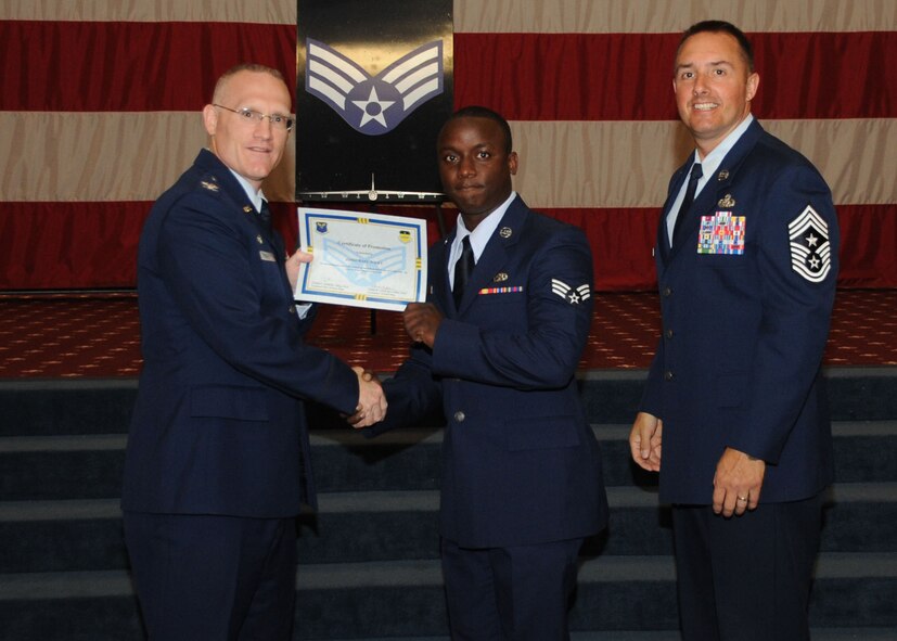 Senior Airman JaMichael Wiley, 2nd Aircraft Maintenance Squadron, receives a certificate of promotion from Col. Michael Adderley, 2nd Operations Group commander, and Chief Master Sgt. Curtis Storms, 2nd Bomb Wing command chief, during the Wing Promotion Ceremony on Barksdale Air Force Base, La., April 30, 2014. (U.S. Air Force photo/Senior Airman Kristin High)