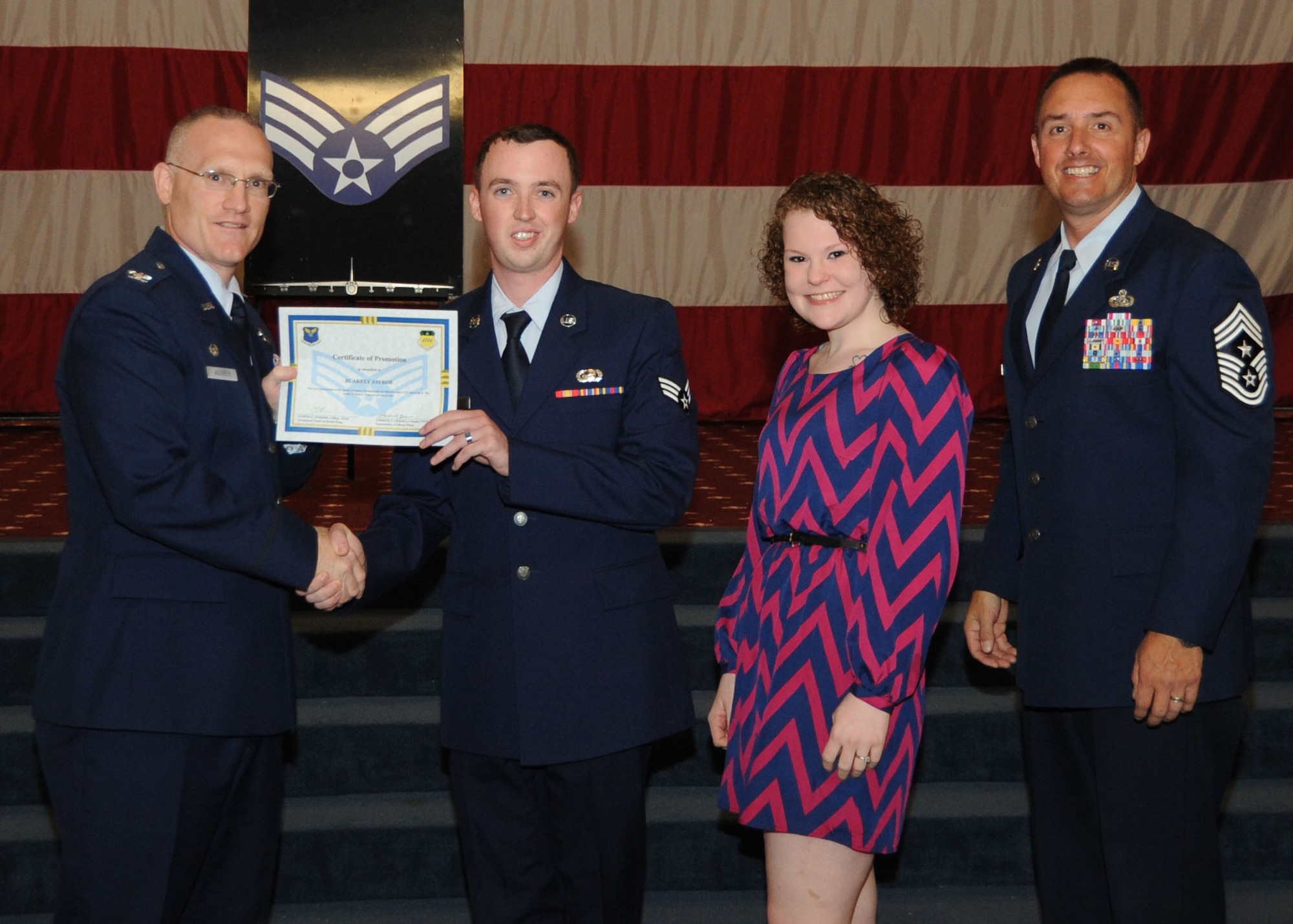 Senior Airman Blakely Jayroe, 2nd Aircraft Maintenance Squadron, receives a certificate of promotion from Col. Michael Adderley, 2nd Operations Group commander, and Chief Master Sgt. Curtis Storms, 2nd Bomb Wing command chief, during the Wing Promotion Ceremony on Barksdale Air Force Base, La., April 30, 2014. (U.S. Air Force photo/Senior Airman Kristin High)
