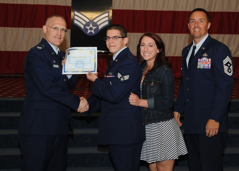 Senior Airman Collin Hughey, 2nd Aircraft Maintenance Squadron, receives a certificate of promotion from Col. Michael Adderley, 2nd Operations Group commander, and Chief Master Sgt. Curtis Storms, 2nd Bomb Wing command chief, during the Wing Promotion Ceremony on Barksdale Air Force Base, La., April 30, 2014. (U.S. Air Force photo/Senior Airman Kristin High)