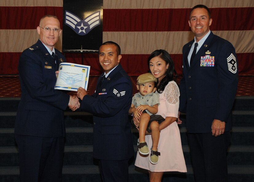 Senior Airman Jovie Abaya, 2nd Aircraft Maintenance Squadron, receives a certificate of promotion from Col. Michael Adderley, 2nd Operations Group commander, and Chief Master Sgt. Curtis Storms, 2nd Bomb Wing command chief, during the Wing Promotion Ceremony on Barksdale Air Force Base, La., April 30, 2014. (U.S. Air Force photo/Senior Airman Kristin High)