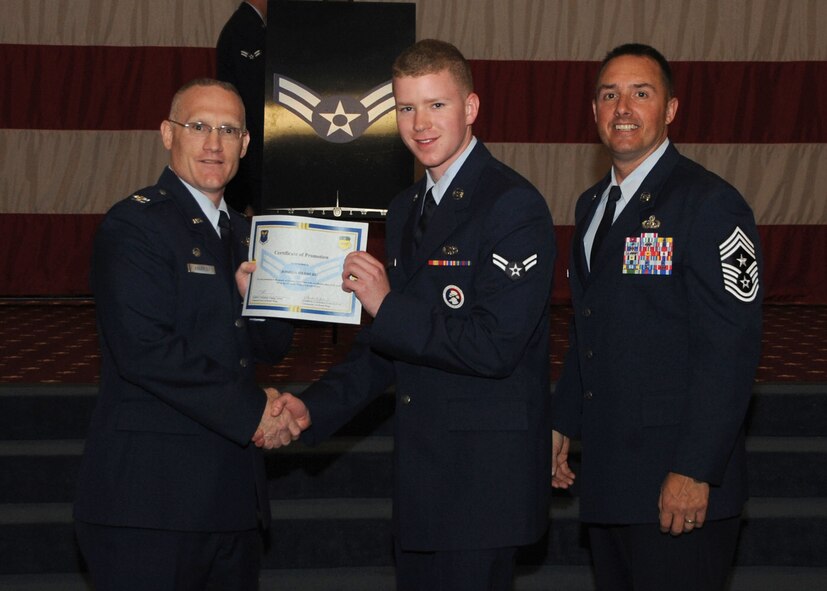 Airman 1st Class Joshua Hedberg, 2nd Maintenance Squadron, receives a certificate of promotion from Col. Michael Adderley, 2nd Operations Group commander, and Chief Master Sgt. Curtis Storms, 2nd Bomb Wing command chief, during the Wing Promotion Ceremony on Barksdale Air Force Base, La., April 30, 2014. (U.S. Air Force photo/Senior Airman Kristin High)