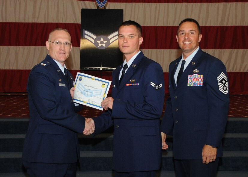 Airman 1st Class Tyler Tanner, 2nd Communications Squadron, receives a certificate of promotion from Col. Michael Adderley, 2nd Operations Group commander, and Chief Master Sgt. Curtis Storms, 2nd Bomb Wing command chief, during the Wing Promotion Ceremony on Barksdale Air Force Base, La., April 30, 2014. (U.S. Air Force photo/Senior Airman Kristin High)