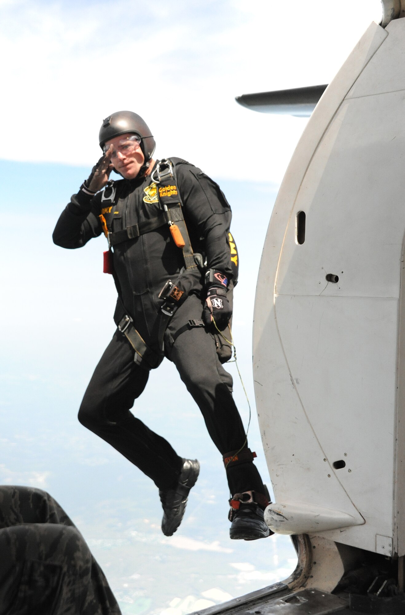 Army Sgt. David Flynn salutes as he jumps from his aircraft for an Army Golden Knights parachute demonstration at the Open House and Air Show May 11, 2014, at Joint Base McGuire-Dix-Lakehurst, N.J. The Open House and Air Show provided more than 300,000 visitors an opportunity to learn more about America's only tri-service joint base, which included demonstrations and static displays of aircraft and vehicles from all five services and various civilian agencies throughout the two-day event.  (U.S. Air Force photo by Airman 1st Class Sean M. Crowe/Released)