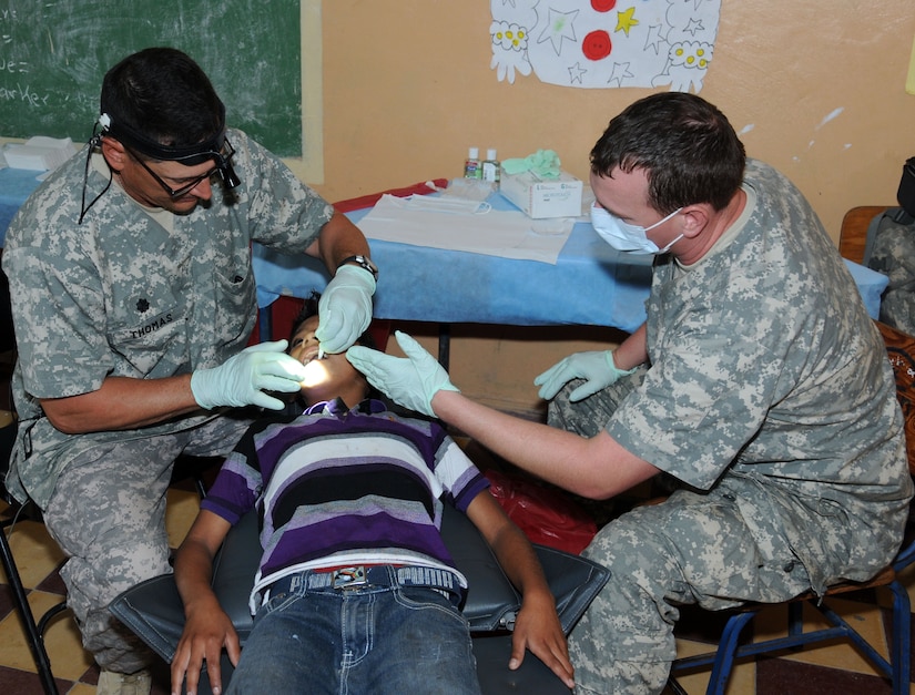 U. S. Army Lt. Col. Mauri Thomas performs a tooth extraction on a Honduran child during a Medical Readiness Training Exercise (MEDRETE) May 8.  The MEDRETE was conducted by Joint Task Force-Bravo's Medical Element, with support from the JTF-Bravo Joint Security Forces and Army Forces Battalion, in partnership with the Honduran Ministry of Health and the Honduran military to provide medical care to more than 720 people in the remote village of La Arena in the Copan region of Honduras.  The team worked together to provide preventative medicine to the villagers, including classes on hygiene, preventative dental care and nutrition.  They also provided immunizations to children, dental care, wellness checkups, medications and minor medical procedures.  (Photo by U. S. Air National Guard Capt. Steven Stubbs)