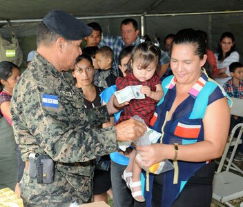 A Honduran woman and her child receives vitamins and medicine from a Honduran military service member during a Medical Readiness Training Exercise (MEDRETE) May 8.  The MEDRETE was conducted by Joint Task Force-Bravo's Medical Element, with support from the JTF-Bravo Joint Security Forces and Army Forces Battalion, in partnership with the Honduran Ministry of Health and the Honduran military to provide medical care to more than 720 people in the remote village of La Arena in the Copan region of Honduras.  The team worked together to provide preventative medicine to the villagers, including classes on hygiene, preventative dental care and nutrition.  They also provided immunizations to children, dental care, wellness checkups, medications and minor medical procedures.  (Photo by U. S. Air National Guard Capt. Steven Stubbs)