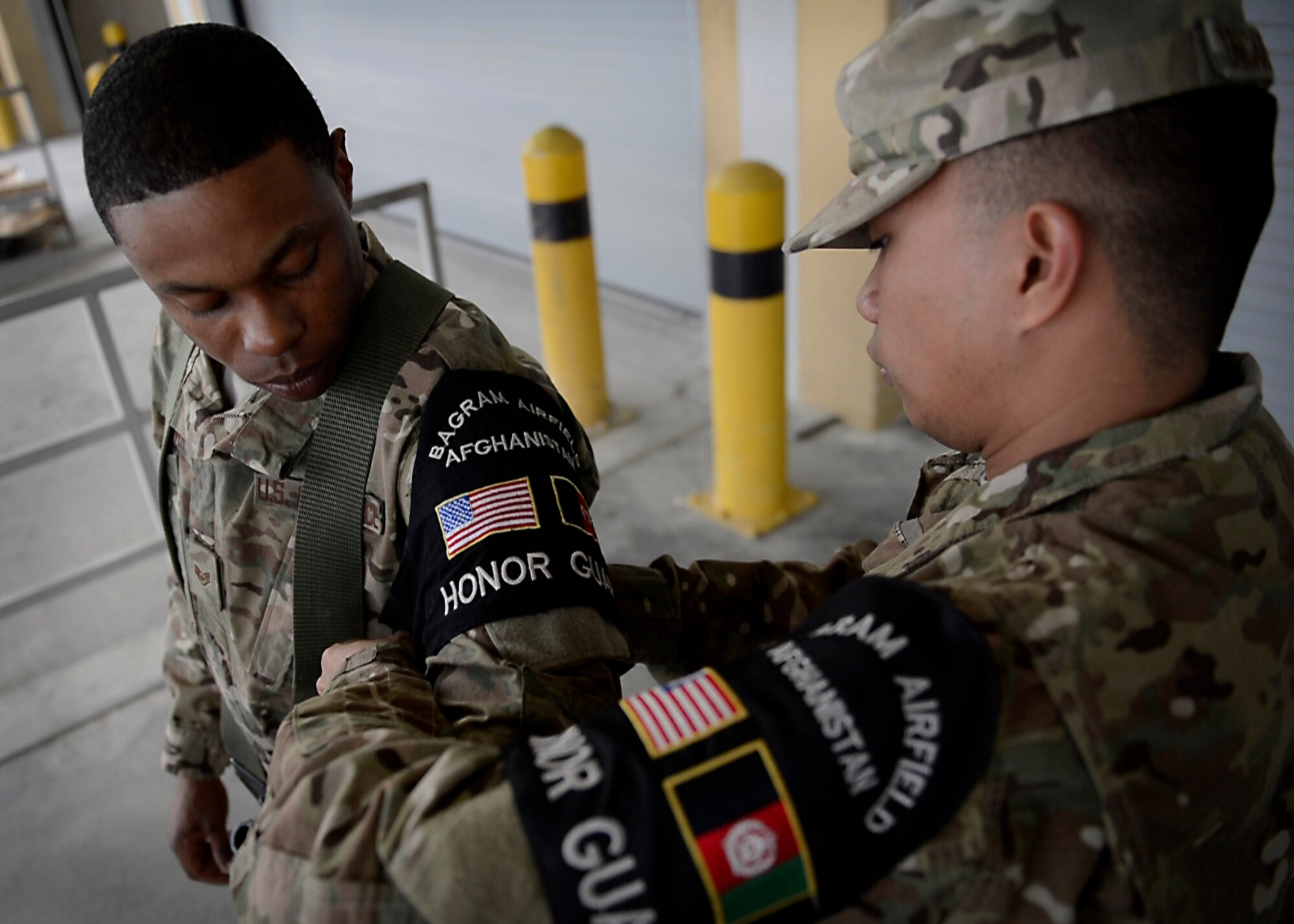 Senior Airman Jerick Encarnacion adjusts Staff Sgt. Bryant Brown’s Honor Guard sleeve before a Change of Command ceremony May 9, 2014 at Bagram Airfield, Afghanistan.  Encarnacion and Bryant are part of the 455th Expeditionary Logistics Readiness  Squadron and Bagram’s honor guard.  As honor guardsmen, they demonstrate dedication, commitment and precision, as well as flawless excecution of ceremonial drills. Encarnacion is deployed from Eielson Air Force Base, Alaska and a native of Vallejo, Calif.  Brown is deployed from Scott Air Force, Base, Ill. and a native of Baltimore, Md. (U.S. Air Force by Staff Sgt. Evelyn Chavez/Released)