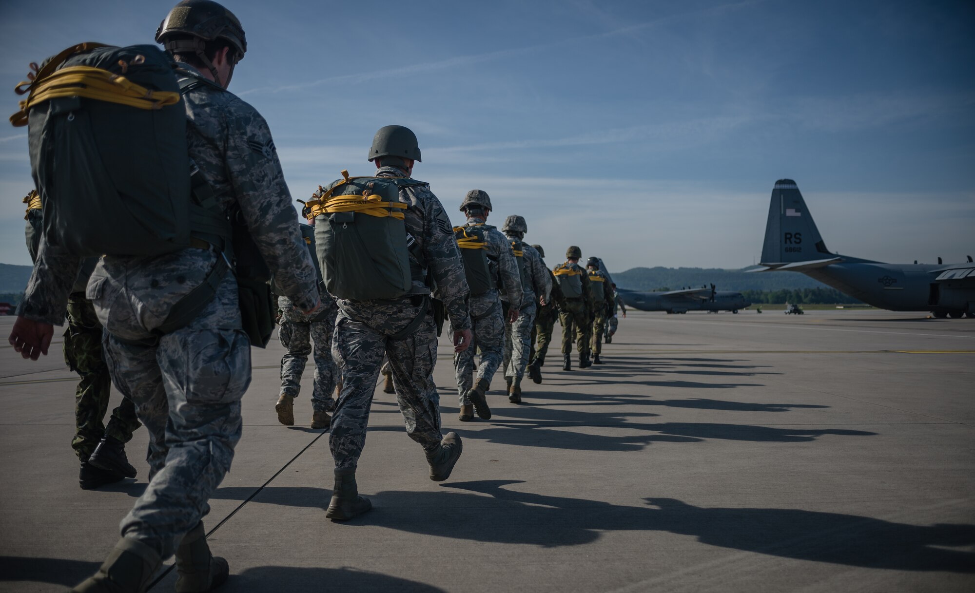 American service member parachutists, along with parachutists from eight visiting countries, prepare to board a C-130J Super Hercules as part of International Jump Week on Ramstein Air Base, Germany, May 5, 2014. A total of 97 foreign and allied partners tested, built and strengthened partnerships during jump week alongside American Airmen and Soldiers. (U.S. Air Force photo/Airman 1st Class Jordan Castelan)