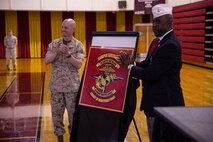 Lt. Col. Jesse Kemp (left), the commanding officer of 2nd Supply Battalion, 2nd Marine Logistics Group, and Dr. James Averhart Jr., the national president of the Montford Point Marine Association stand before the unit's new logo during a ceremony aboard Camp Lejeune, N.C., May 6, 2014. The new logo links the battalion with the heritage of the African-American Marines who trained at Montford Point, N.C., and carried out logistical missions in the Pacific during World War II