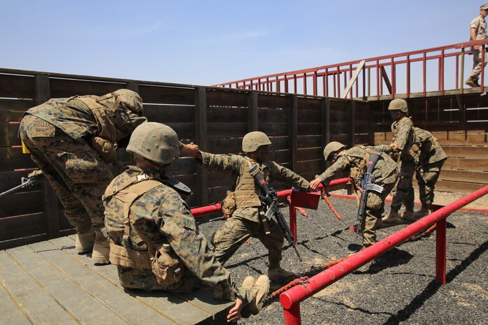 Company A Marines, 1st Recruit Training Battalion, pull together as a unit to help one another across an obstacle in stall six at the Leadership Reaction Course during the Crucible at Edson Range, April 30. Each obstacle was set up inside wooden stalls which made 12 stalls with 12 obstacles. Before each starting each event, Marines were given a set of tools and instructions to complete each mission.