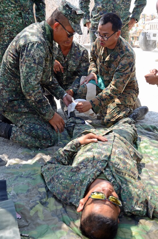 Philippine Marines and a U.S. Navy Corpsman prepare to bandage a patient during a simulated casualty exercise during combat lifesaver training at Crow Valley, Philippines, May 8, 2014, during Balikatan 2014. The training was designed for non-medical personnel and developed the skills necessary to administer first aid in a field environment. Balikatan is an annual training exercise that strengthens the interoperability between the armed forces of the Philippines and U.S. military in their commitment to regional security and stability, humanitarian assistance and disaster relief. 