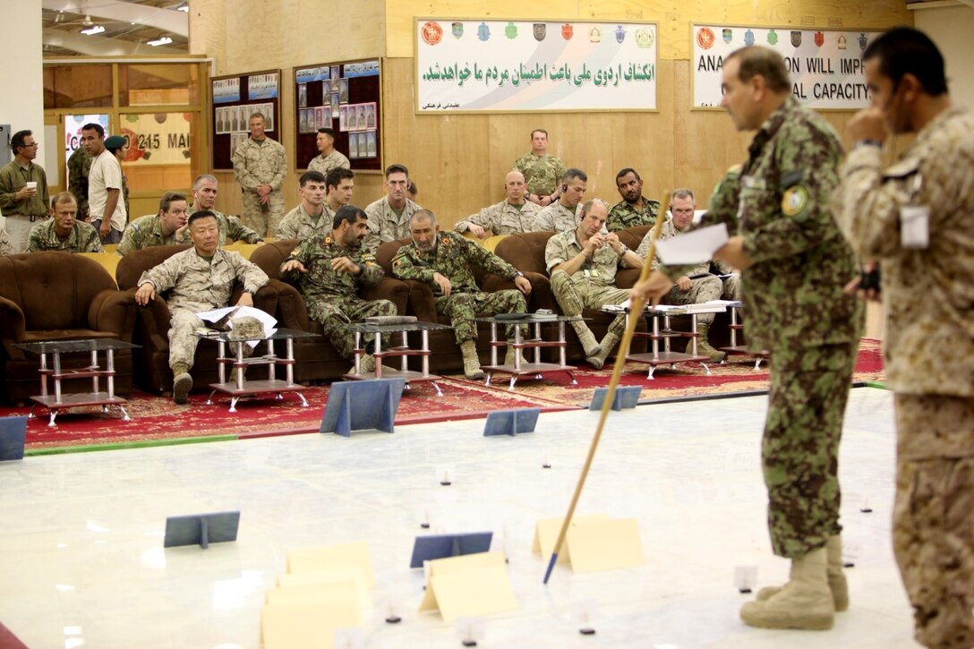 Front row from left to right: Brig. Gen. Daniel Yoo, commander, Regional Command (Southwest); Maj. Gen. Sayed Malouk, commander, 215th Corps, Afghan National Army; Brig. Gen. Zamen Hassan, chief of staff, 215th Corps; Brigadier Robert Thompson, deputy commander,RC(SW) and Col. Christopher Dowling, senior advisor and officer in charge, Operational Coordination Center - Regional, are briefed on the movements of the Afghan National Army during the final retrograde convoy of U.S. Marines and sailors out of Sangin, Afghanistan at a Rehearsal of Concept exercise aboard Camp Shorabak, May 1, 2014.